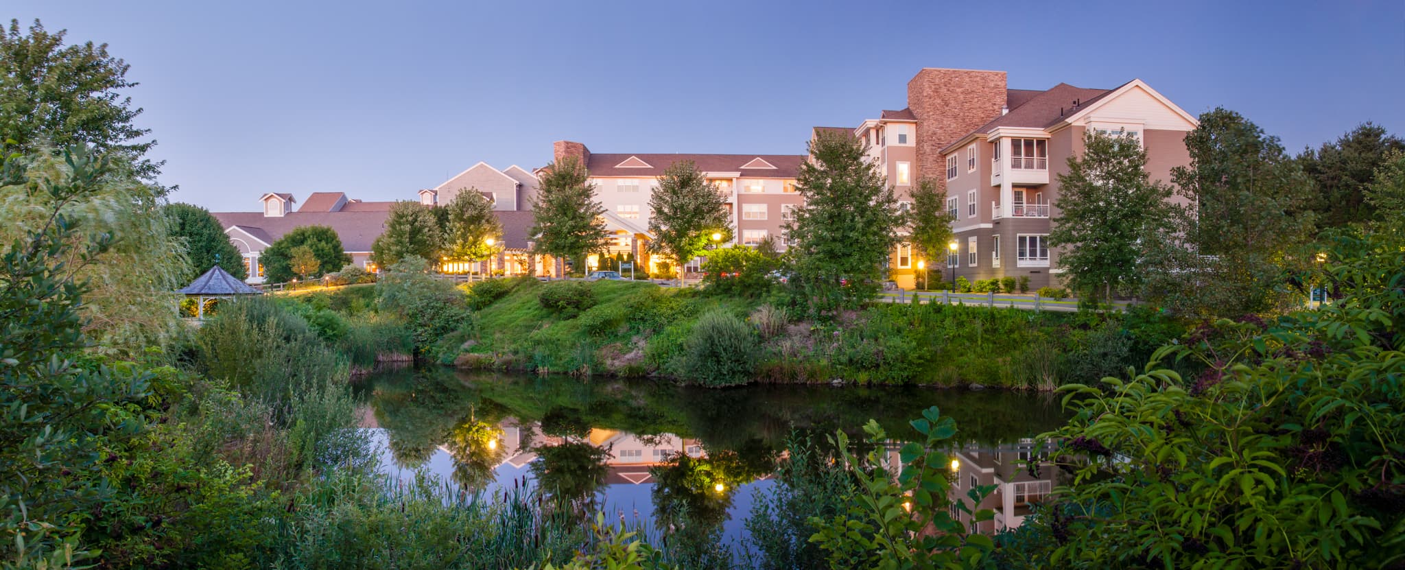 The Brookhaven at Lexington campus at dusk, seen across the pond
